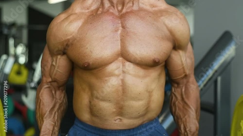 slow motion Brutal strong bodybuilder athletic man pumping up muscles workout bodybuilding concept background - muscular bodybuilder handsome men doing exercises in gym naked torso sport and diet