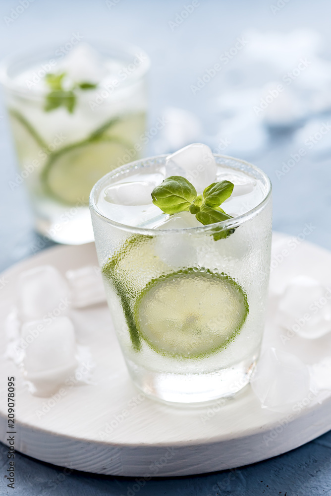 Healthy Lemonade Lime with Fresh Mint and Ice in a Glass on Blue Background Tasty Homemade Detox Water Infused Water Vertical Healthy Lemonade Lime with Fresh Mint and Ice in a Glass on Blue Background Tasty Homemade Detox Water Infused Water Vertical