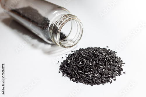 activated carbon or granular in clear bottle is used in air purification, decaffeinate, gold purification, metal extraction, water purification, medicine, sewage treatment, air filters in gas masks photo