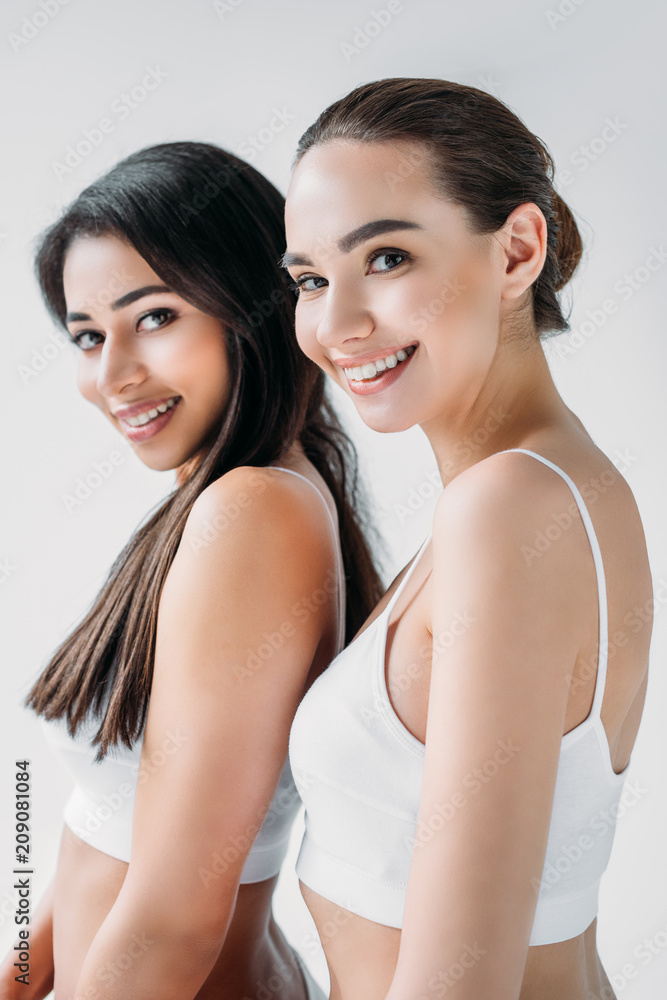 smiling attractive multicultural women posing isolated on gray background smiling attractive multicultural women posing isolated on gray background