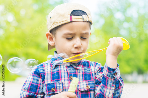 Fotografia brown-eyed boy blowing bubbles