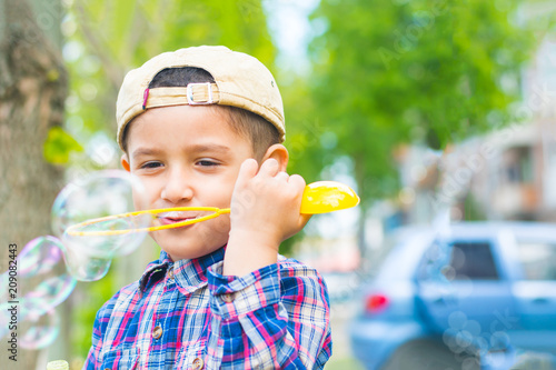 Obraz na plátne brown-eyed boy blowing bubbles