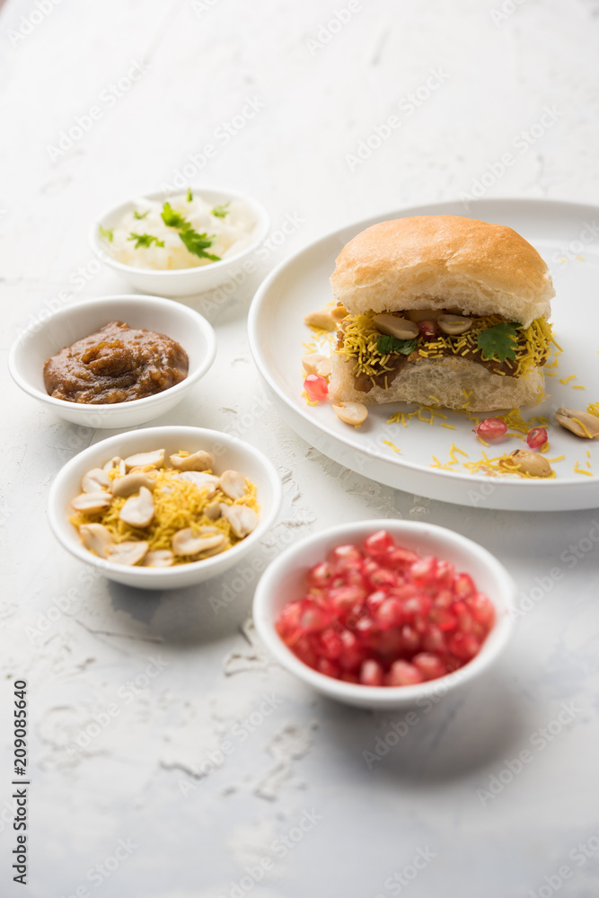 Dabeli is an Indian snack item served with Pomegranate Seeds and Cilantro in white ceramic plate. It's a popular Navratri Festival food