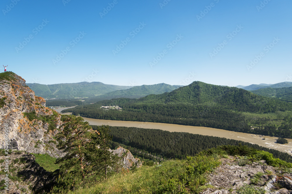Man standing on top of cliff in summer beauty day in Altai mountains Man standing on top of cliff in summer beauty day in Altai mountains
