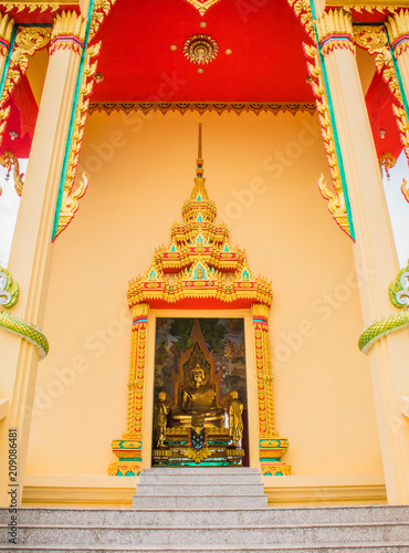 buddha statue  view through the door of temple © Peerapixs