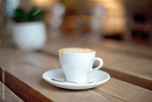 cup of coffee with milk on wooden table