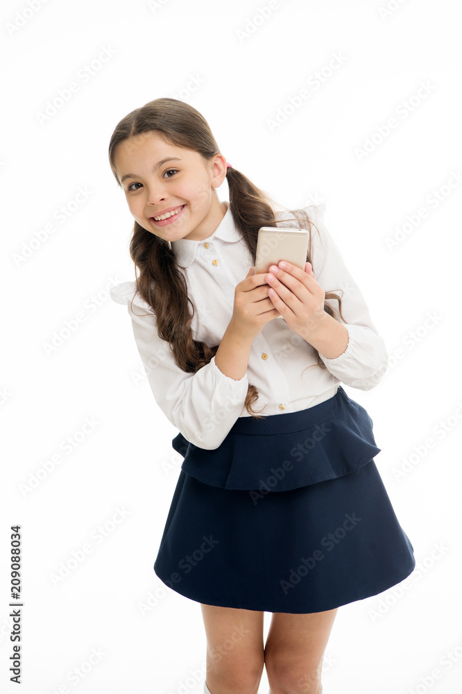 Girl cute long curly hair holds smartphone white background. Child girl school uniform clothes holds smartphone. Child school uniform smart kid happy face. Parental advisory concept. Always in touch Girl cute long curly hair holds smartphone white background. Child girl school uniform clothes holds smartphone. Child school uniform smart kid happy face. Parental advisory concept. Always in touch