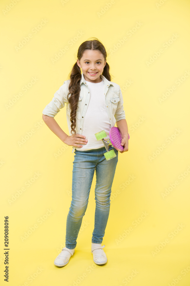 Child cool and confident likes skateboarding. Joyful and happy. Kid girl casual style with penny board enjoy childhood. Girl joyful happy with skateboard yellow background. Hobby and leisure concept Child cool and confident likes skateboarding. Joyful and happy. Kid girl casual style with penny board enjoy childhood. Girl joyful happy with skateboard yellow background. Hobby and leisure concept