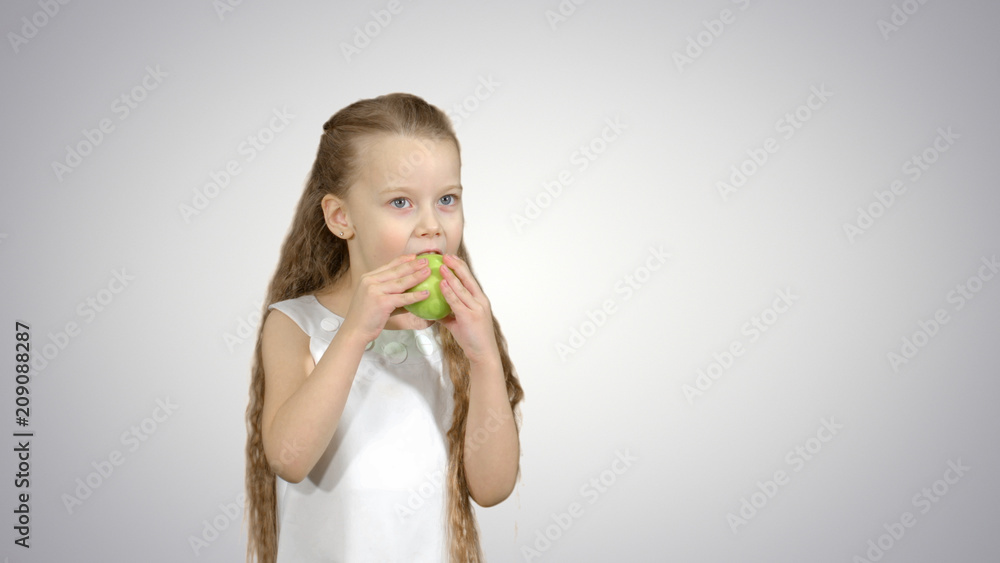 Portrait of a little girl eating green apple on white background Portrait of a little girl eating green apple on white background