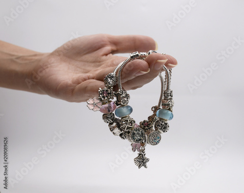 Luxury silver bracelets in women hand on white background. Green bracelets in hand