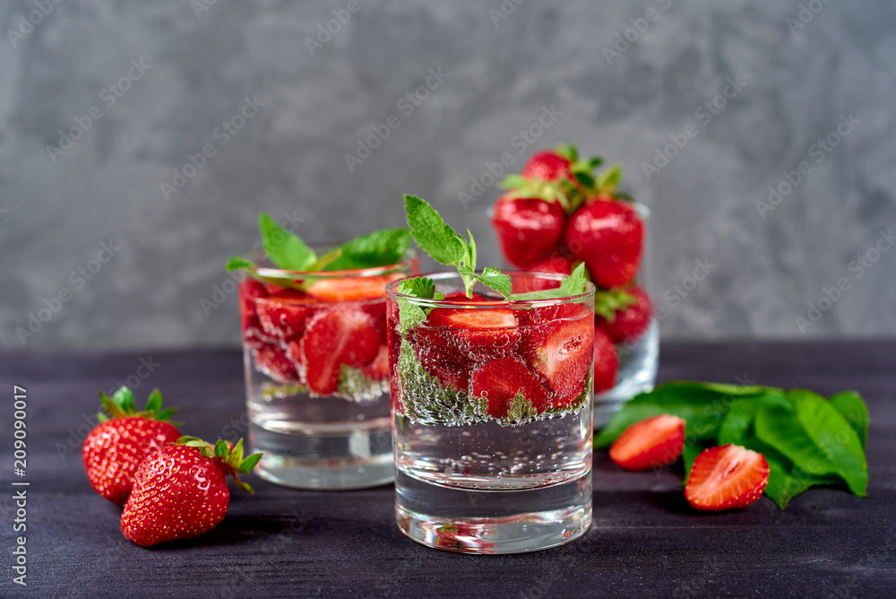 Lemonade drink of soda water, strawberry and mint leaves in glass on wooden table, copy space. Refreshing summer berry drink. Sparkling water drink with slices of strawberry. Detox fruit in water Lemonade drink of soda water, strawberry and mint leaves in glass on wooden table, copy space. Refreshing summer berry drink. Sparkling water drink with slices of strawberry. Detox fruit in water