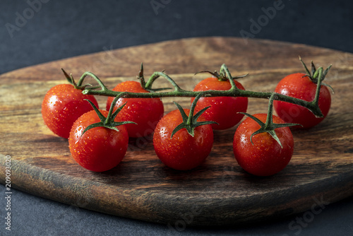 Tomatoes on the vine on wooden board
