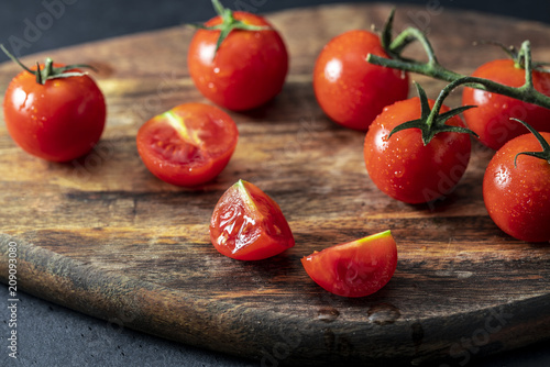 Tomatoes on the vine on wooden board