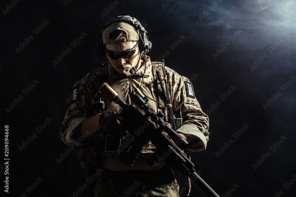 Special forces soldier with rifle on dark background
