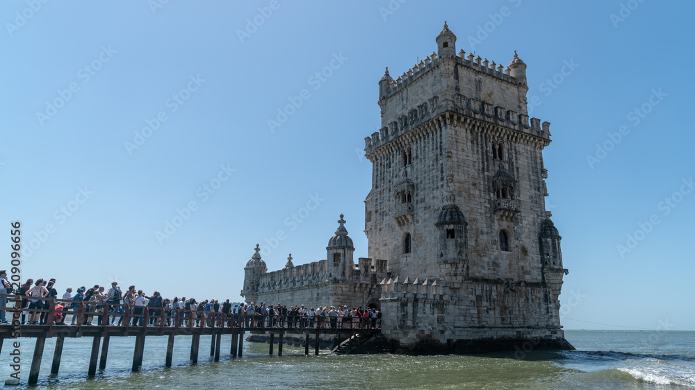 Tourists in queue to visit the Belem tower at the bank of Tejo River in Lisbon, Portugal
