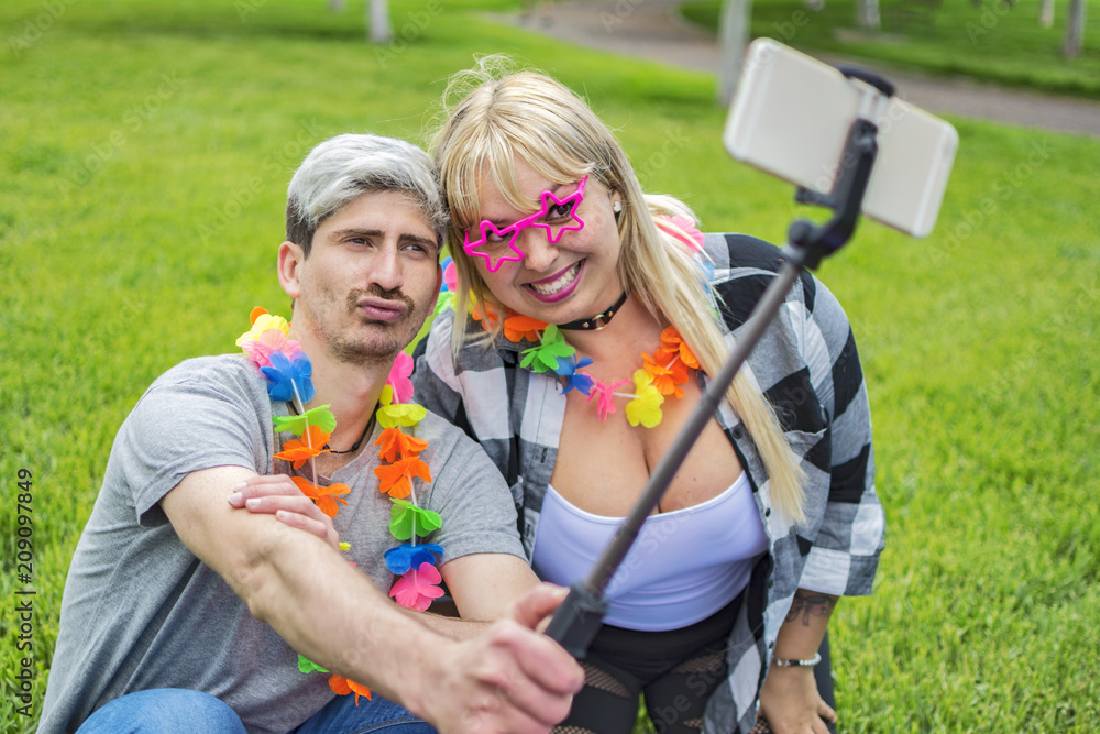 Two friends partying in a park, they make a selfie. Two friends partying in a park, they make a selfie.