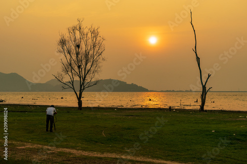 scenic of photographer take a photo of sunset at reservoir