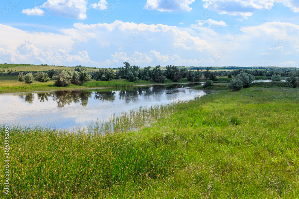 Summer landscape with small river and blue cloudy sky Summer landscape with small river and blue cloudy sky