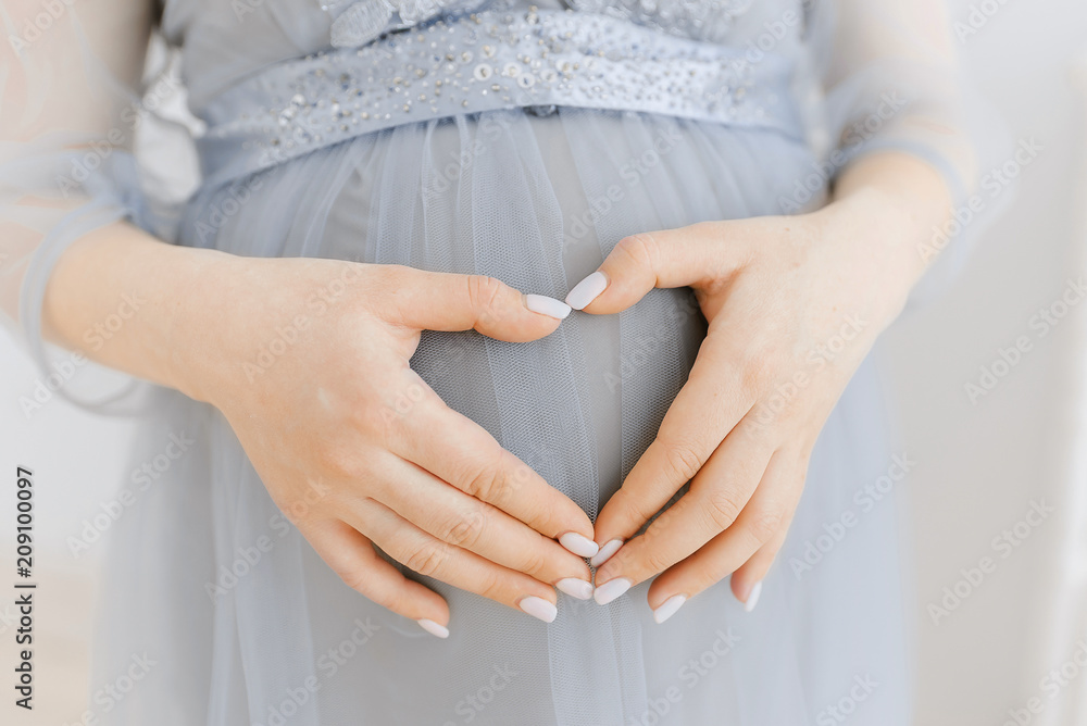 belly of a pregnant girl close-up. Gray dress. A gentle embrace and stroking the pregnant belly. belly of a pregnant girl close-up. Gray dress. A gentle embrace and stroking the pregnant belly.