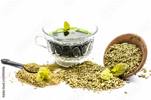 Raw fennel with its powder and its beneficial tea or extract in a transparent cup isolated on white. photo