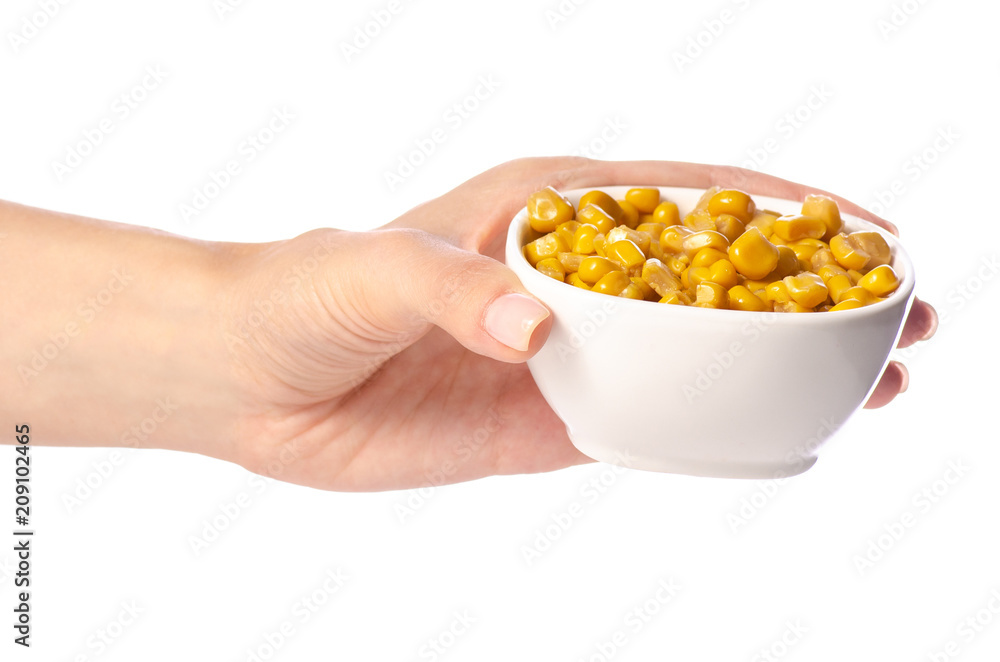 Canned corn in a bowl in a hand on a white background isolation Canned corn in a bowl in a hand on a white background isolation