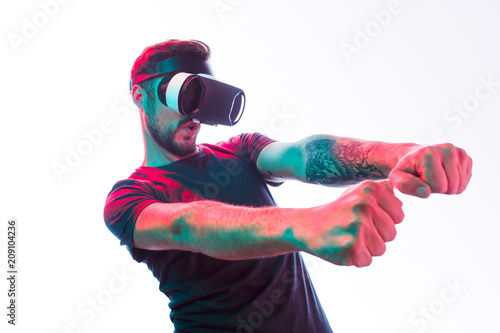 Gaming man in VR goggles on white photo