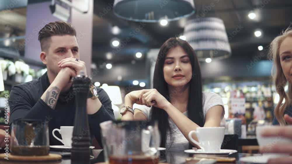 friends laugh and have fun sitting at a table in a restaurant. A company of friends spends time together and enjoys socializing. friends laugh and have fun sitting at a table in a restaurant. A company of friends spends time together and enjoys socializing.
