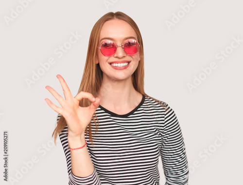 Trendy girl showing OK gesture on white