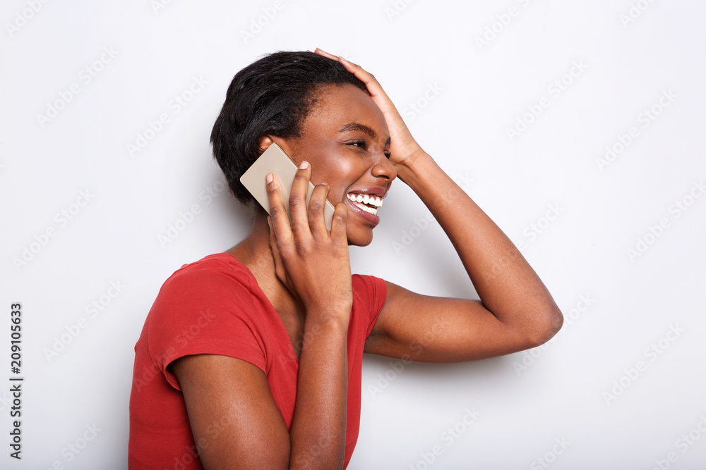 Side portrait of happy black woman talking on mobile phone and laughing Side portrait of happy black woman talking on mobile phone and laughing