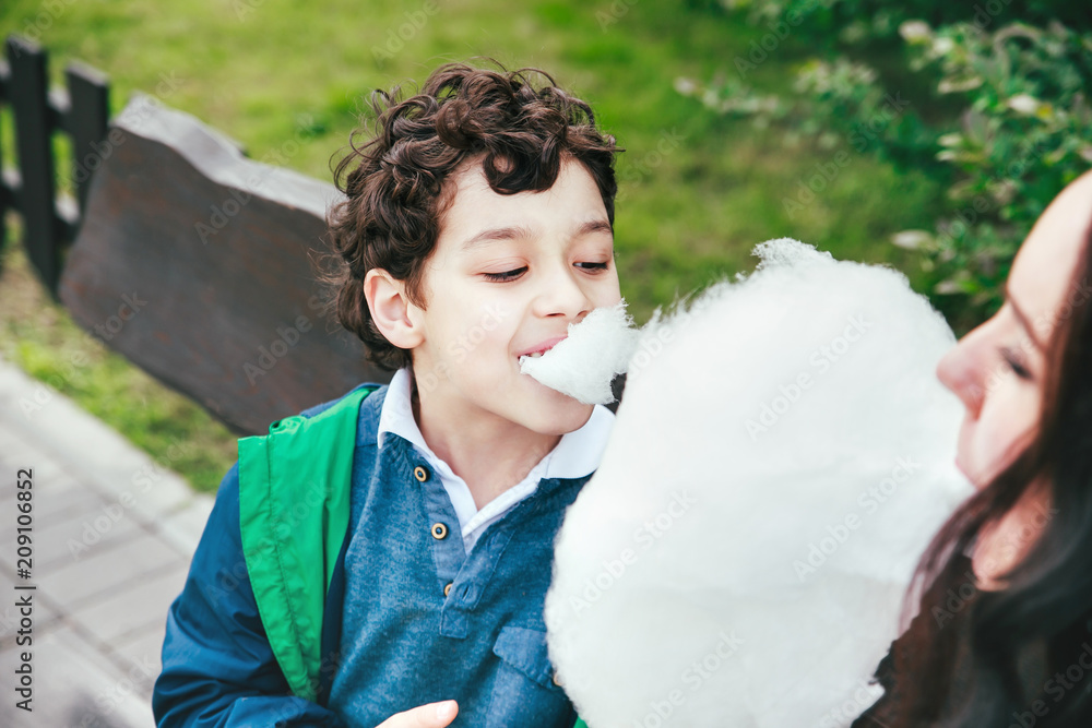 Happy Mother and son eating cotton candy in park Happy Mother and son eating cotton candy in park