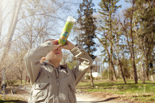 Boy looking at the kaleidoscope outdoors