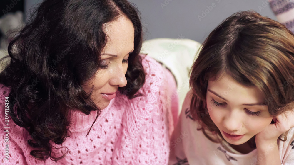 Mother talking with daughter before bedtime, sweet moments together, closeup Mother talking with daughter before bedtime, sweet moments together, closeup