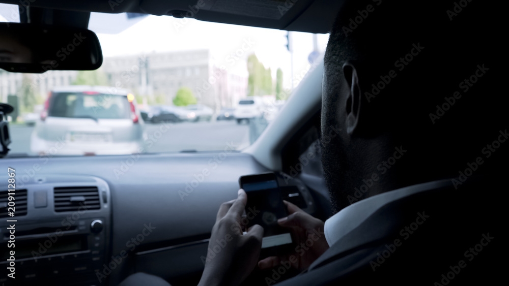 Man going to meeting with partners, looking through company statistics on gadget Man going to meeting with partners, looking through company statistics on gadget