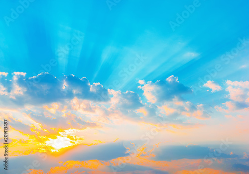 Sunrise dramatic blue sky with orange sun rays breaking through the clouds. Nature background. Hope concept