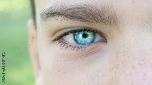 Portrait of a boy looking at the camera. The bright blue right eye of a boy of ten years closeup photo