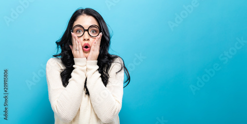 Surprised young woman posing on a solid background