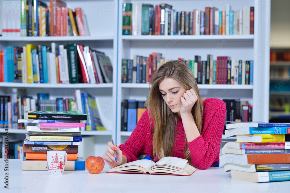 Beautiful female student in a university library Beautiful female student in a university library