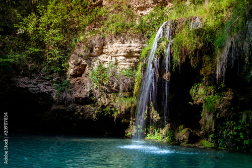 Waterfall and a beautiful lagoon lake for relaxing in the summer forest.