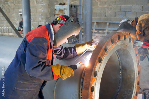Two welders are welded, by manual arc welding, a flange DN 800 to the pipe