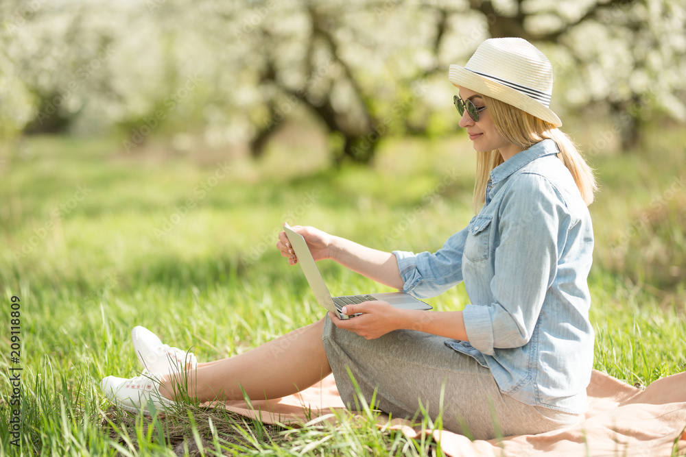 Girl with a smile with a laptop outdoors. The concept of freelancing and work in nature Girl with a smile with a laptop outdoors. The concept of freelancing and work in nature