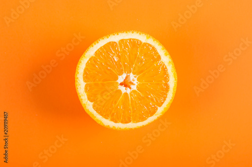 Top view of a half orange fruit on an orange colored background