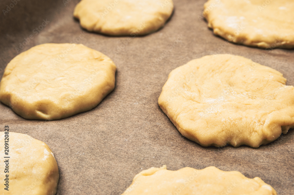Home handmade baking, the dough on parchment paper for baking Home handmade baking, the dough on parchment paper for baking