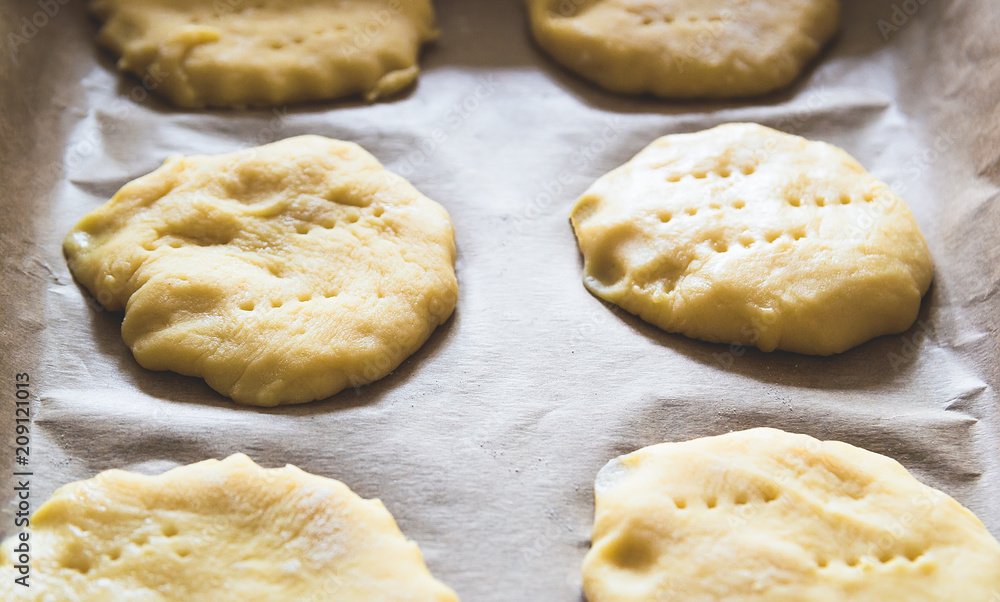 Home handmade baking, the dough on parchment paper for baking Home handmade baking, the dough on parchment paper for baking