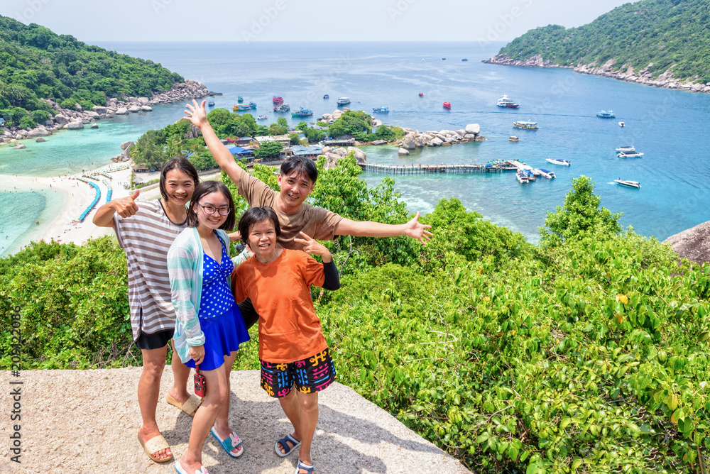 Fototapeta premium Thai family tourists is posing happily on top of the Koh Nang Yuan island is a high viewpoint and beautiful natural landscape is a famous attractions in the Gulf of Thailand, Surat Thani, Thailand