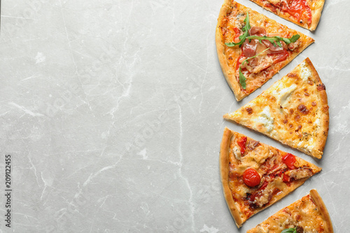 Slices of delicious pizza on light background, top view