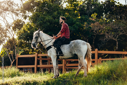 Young man riding white horse on the countryside © kleberpicui