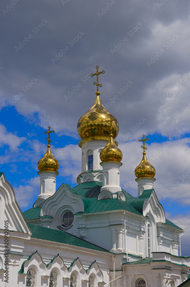 Beatiful golden domes of orthodox church on a background of overcast sky.