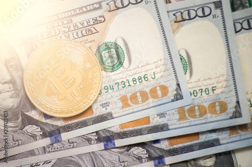 gold bitcoin on the background of dollars