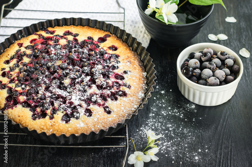 Homemade baked currant pie on a dark wooden background.