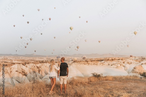 Romantic couple looking at hot air balloons in Cappadocia